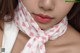 A close up of a woman wearing a pink and white scarf.