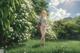 A woman standing in a field of white flowers.