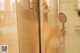 A naked woman taking a shower in a bathroom.