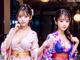 A couple of women in kimonos posing for a picture.