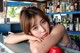 A woman leaning on a counter in front of a bar.