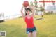 A woman holding a basketball in a field.